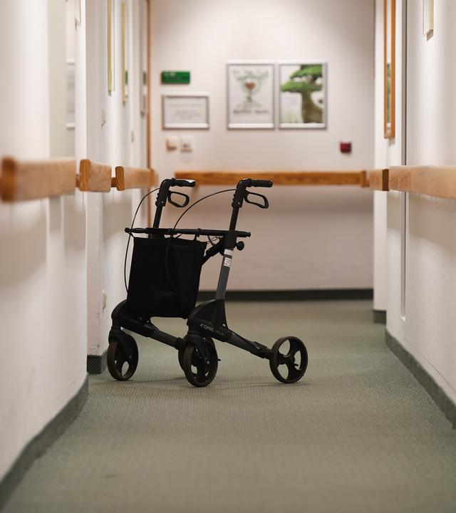 Ein Rollator steht in einem Gang in einem Altersheim.