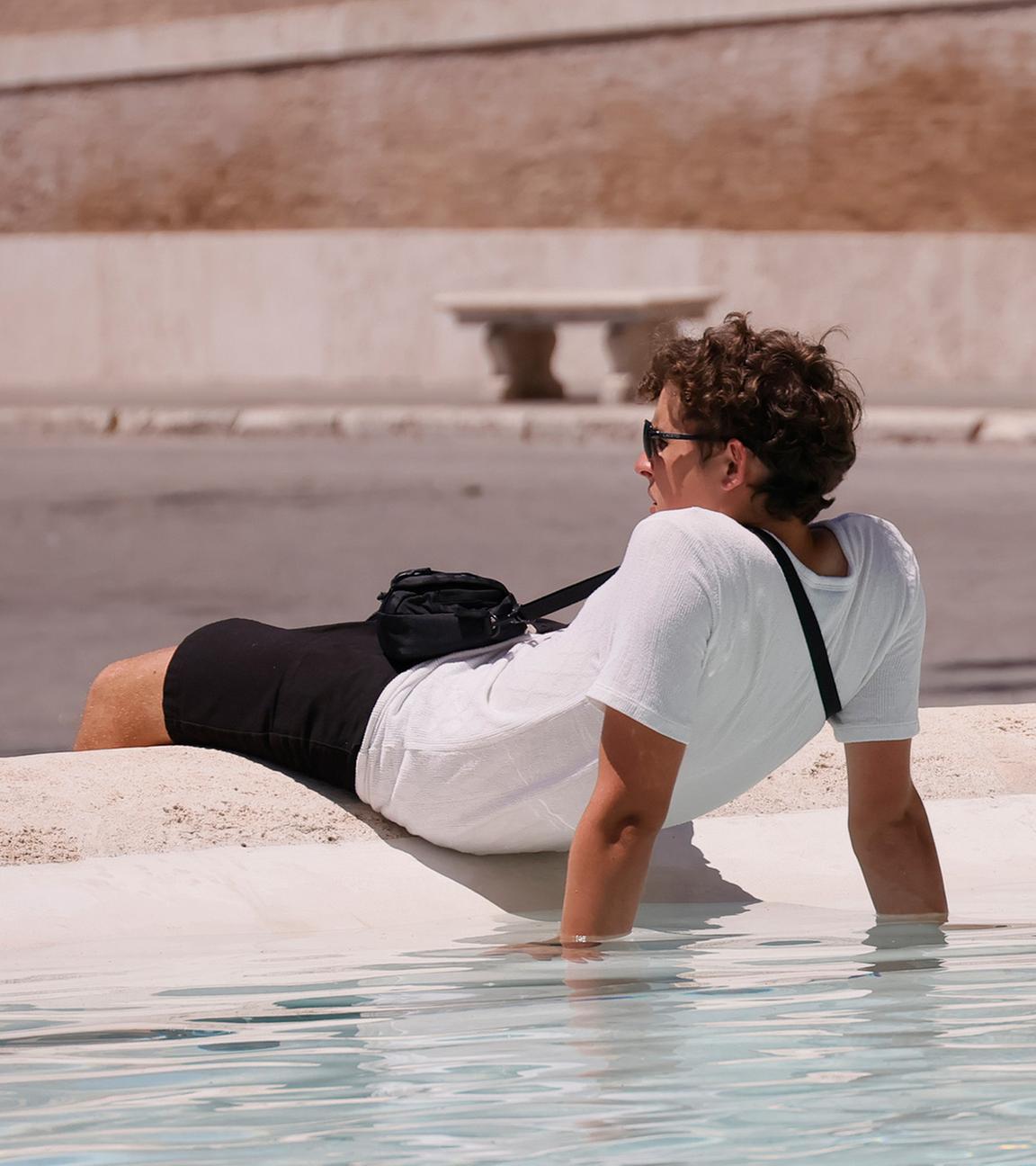 Ein Tourist kühlt sich am 29.06.2025 in einem Brunnen an der Piazza del Popolo in Rom ab.