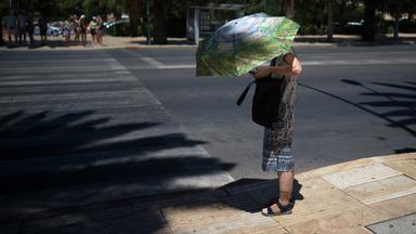 Archiv: Eine Touristin benutzt einen Regenschirm, um sich an einem heißen Sommertag in Málaga, Spanien, am 03.08.2023 vor der Sonne zu schützen.