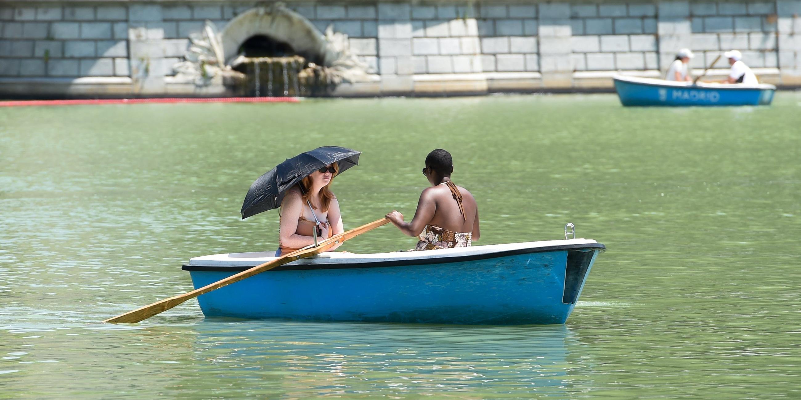 Spanien, Madrid: Zwei Frauen rudern in einem Boot, um sich auf einem Fluss abzukühlen. Archivbild