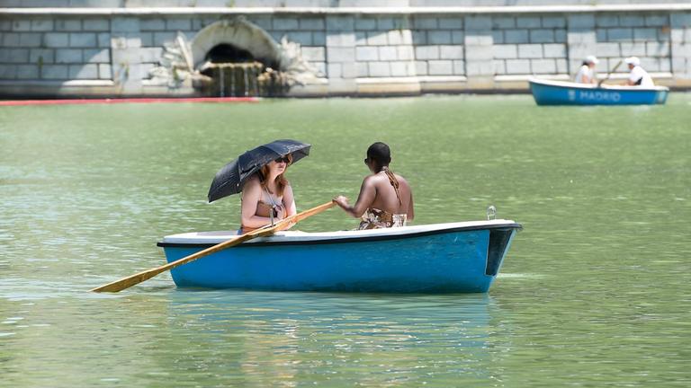 Spanien, Madrid: Zwei Frauen rudern in einem Boot, um sich auf einem Fluss abzukühlen. Archivbild