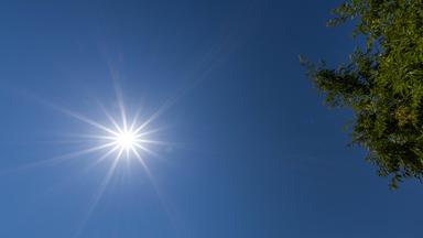 Die Sonne scheint vor blauem Himmel.