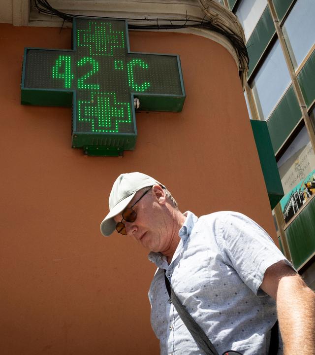 Ein Tourist geht am 20. Juni 2026 in Palma de Mallorca an einem Schild vorbei, auf dem 42 Grad Celsius angezeigt werden – am Vorabend des Beginns der ersten offiziellen Hitzewelle dieses Sommers. Spanien verzeichnete von Juni bis August mehr als 5.000 hitzebedingte Todesfälle, wie Daten eines Instituts für öffentliche Gesundheit am 31. August 2026 zeigten – ein Rekord seit Beginn der statistischen Erfassung im Jahr 2015.