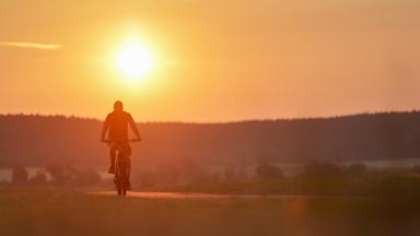 Ein Radfahrer ist am Morgen im Sonnenaufgang in Riedlingen, Baden-Württemberg, unterwegs.