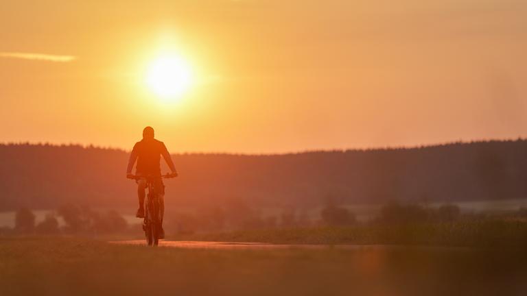 Ein Radfahrer ist am Morgen im Sonnenaufgang in Riedlingen, Baden-Württemberg, unterwegs.