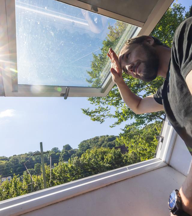 Chemie- und Informatikstudent Johannes Wichert schaut aus dem Dachfenster der WG-Küche im Dachgeschoss