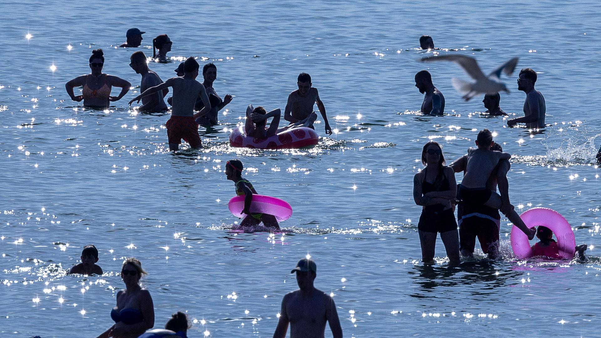 Badegäste nutzen das warme Sonnenwetter für einen Strandbesuch an der Ostseeküste von Warnemünde. (Archiv)
