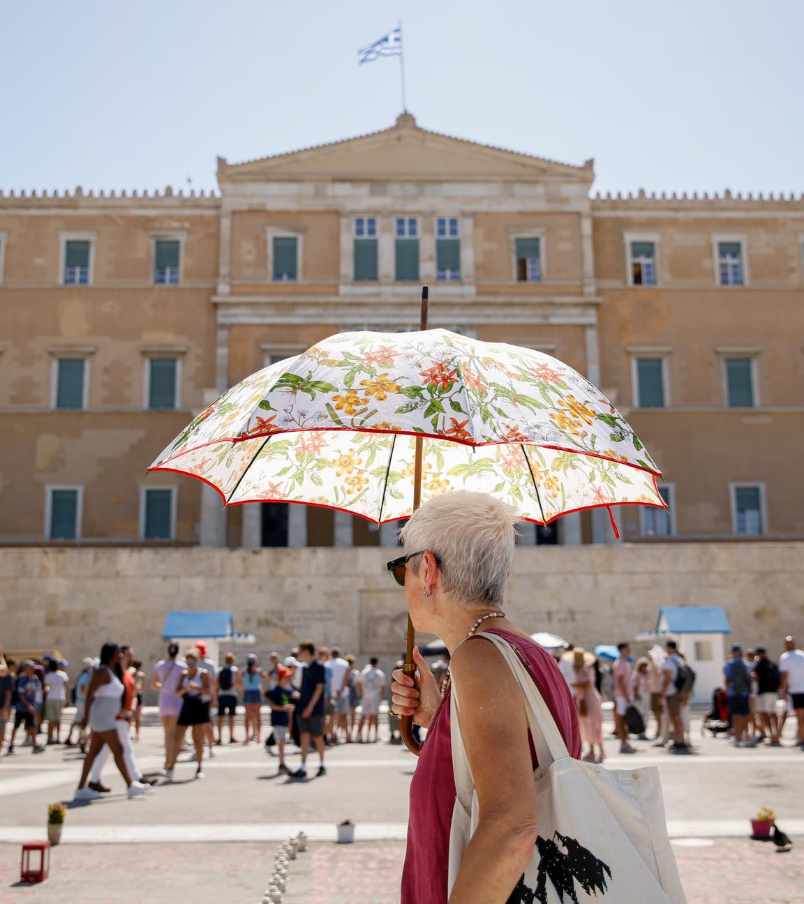 Athen: Eine Frau geht mit einem Regenschirm vor dem griechischen Parlament im Zentrum Athens spazieren.