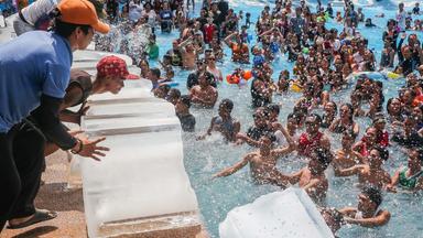 Philippinen, Bulacan: Mitarbeiter schieben Eisblöcke in einen Swimmingpool in einem Resort