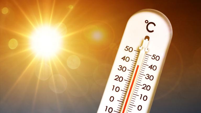 Thermometer vor gleißender Sonne zeigt hohe Temperaturen an