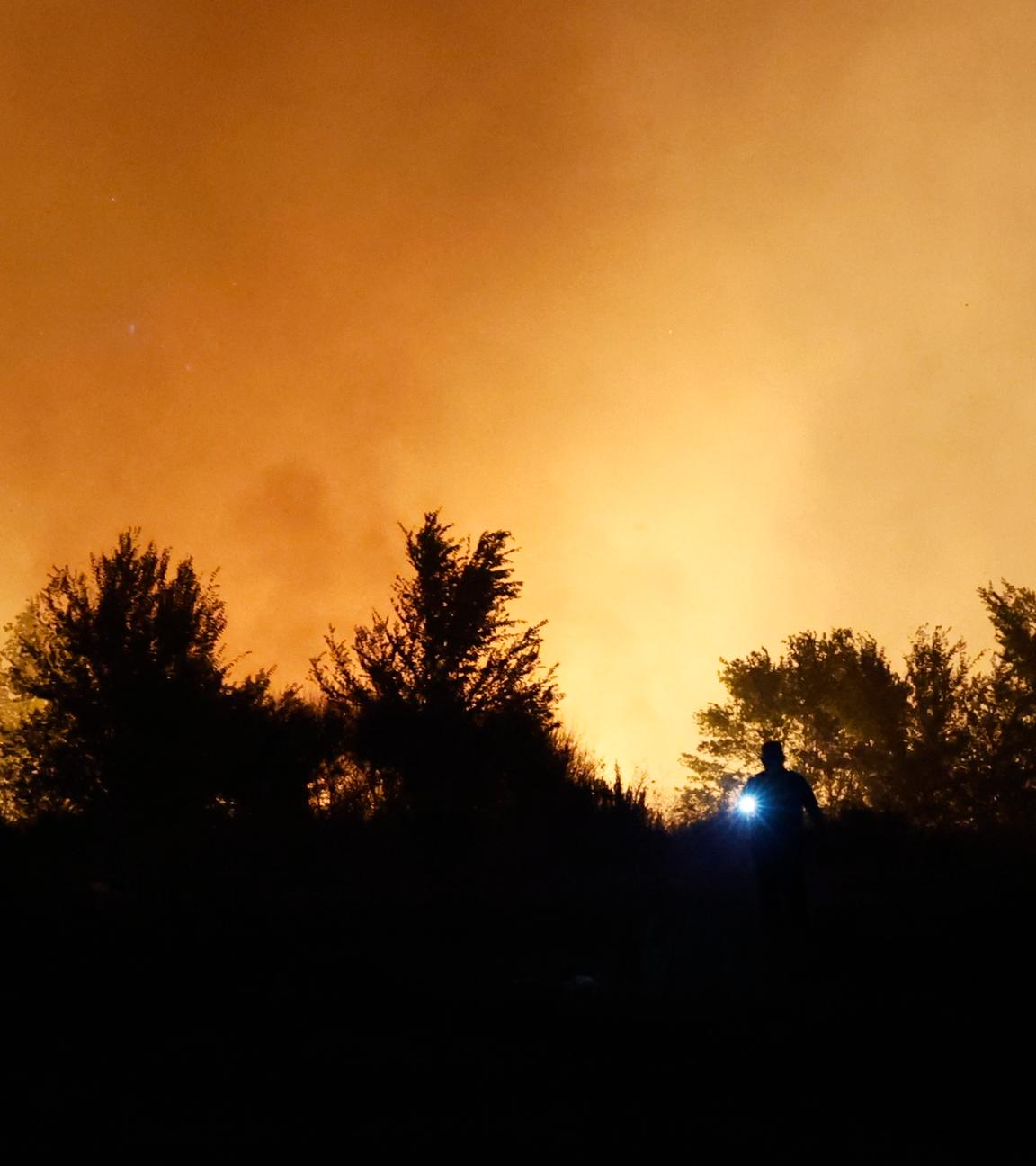 Eine Landschaft in Spanien bei Dunkelheit, welche durch die Waldbrände mit Rauch durchzogen ist