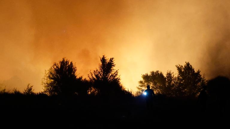 Eine Landschaft in Spanien bei Dunkelheit, welche durch die Waldbrände mit Rauch durchzogen ist