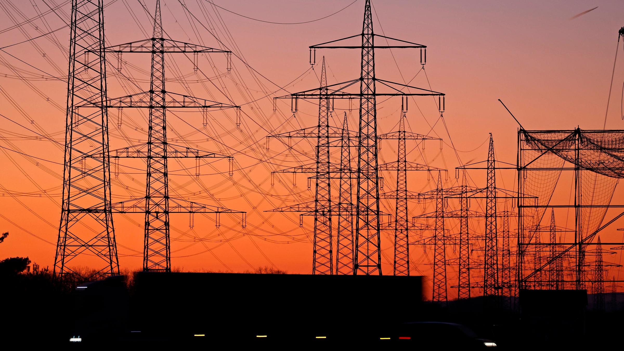 Symbolbild: Hochspannungsmasten bei Sonnenuntergang
