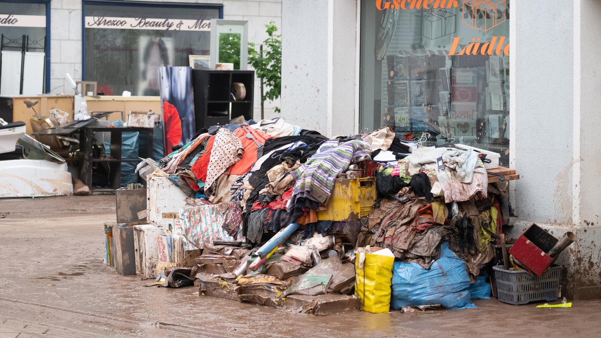 Baden-Württemberg, Rudersberg: Vom Hochwasser zerstörter Hausrat liegt vor einem Einzelhandelsgeschäft in der Ortsmitte.