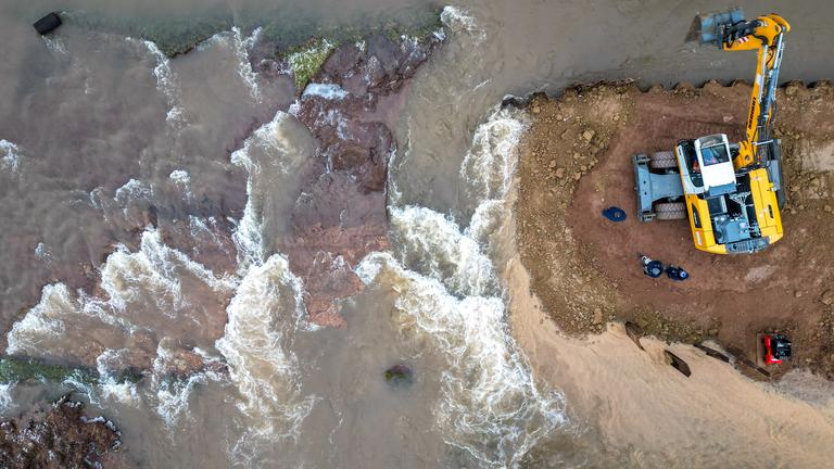 Nach sinkenden Pegelständen wird mit schwerem Gerät die Deichöffnung nördlich von Mönchpfiffel-Nikolausrieth an der Landesgrenze Sachsen-Anhalt und Thüringen wieder verschlossen am 12.01.2024