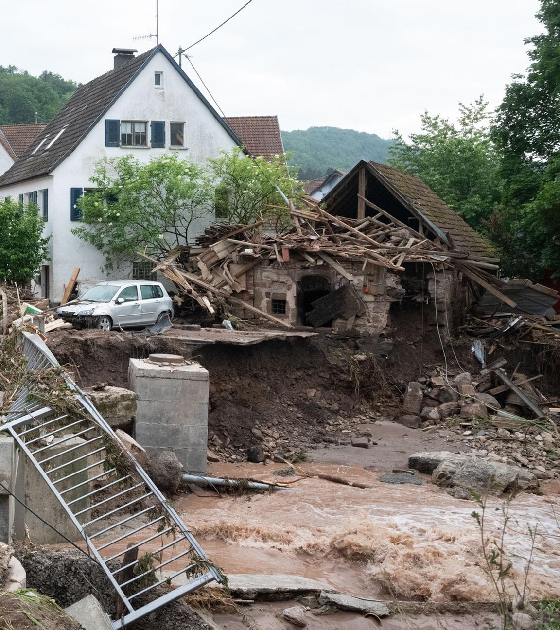Menschen laufen in den Ort Klaffenbach nachdem ein Hochwasser starke Schäden im Ort angerichtet hat. Aufgenommen am 03.06.2024