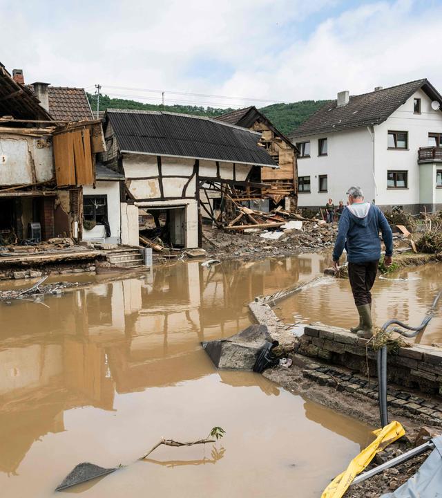 Ein Mann läuft durch das vom Hochwasser zerstörte Gebiet