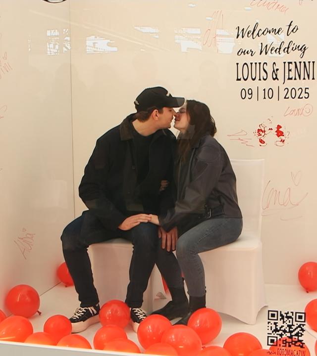 Paar küsst sich in einer Glasbox