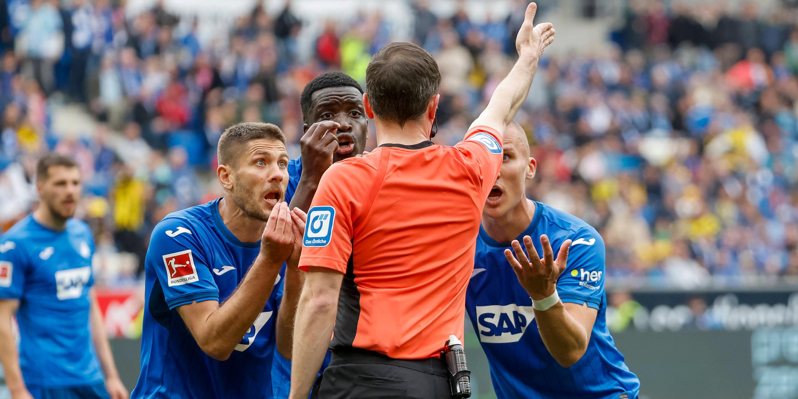 Hoffenheims Spieler diskutieren mit Schiedsrichter Benjamin Brand beim Spiel gegen Dortmund.