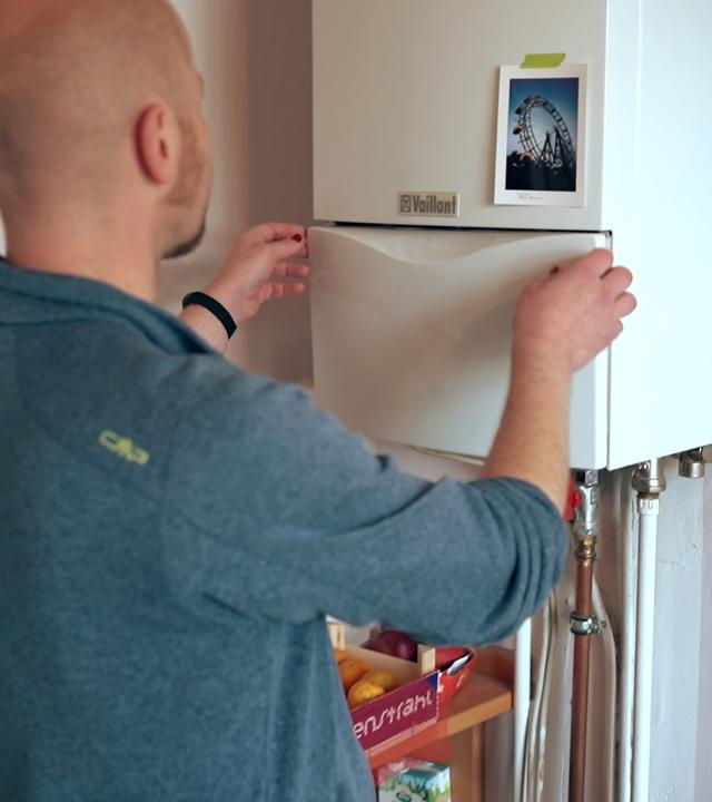 Mann steht vor seiner Gastherme