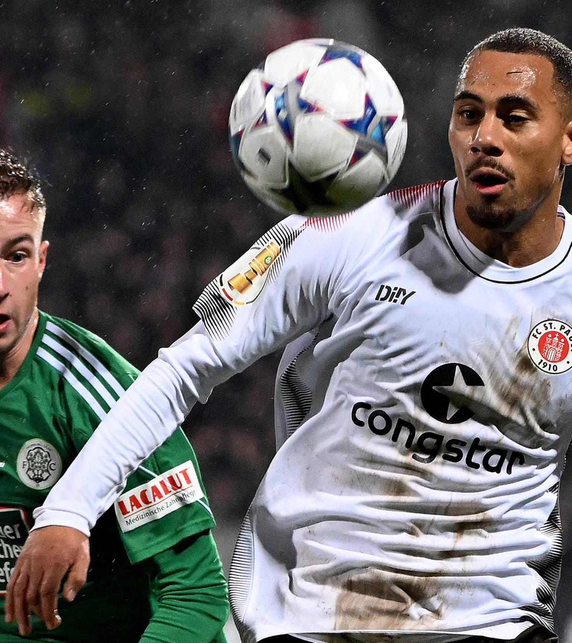 Tim Steinmetz (FC Homburg) und Etienne Amenyido (FC St.Pauli) im Zweikampf am 05.12.23.