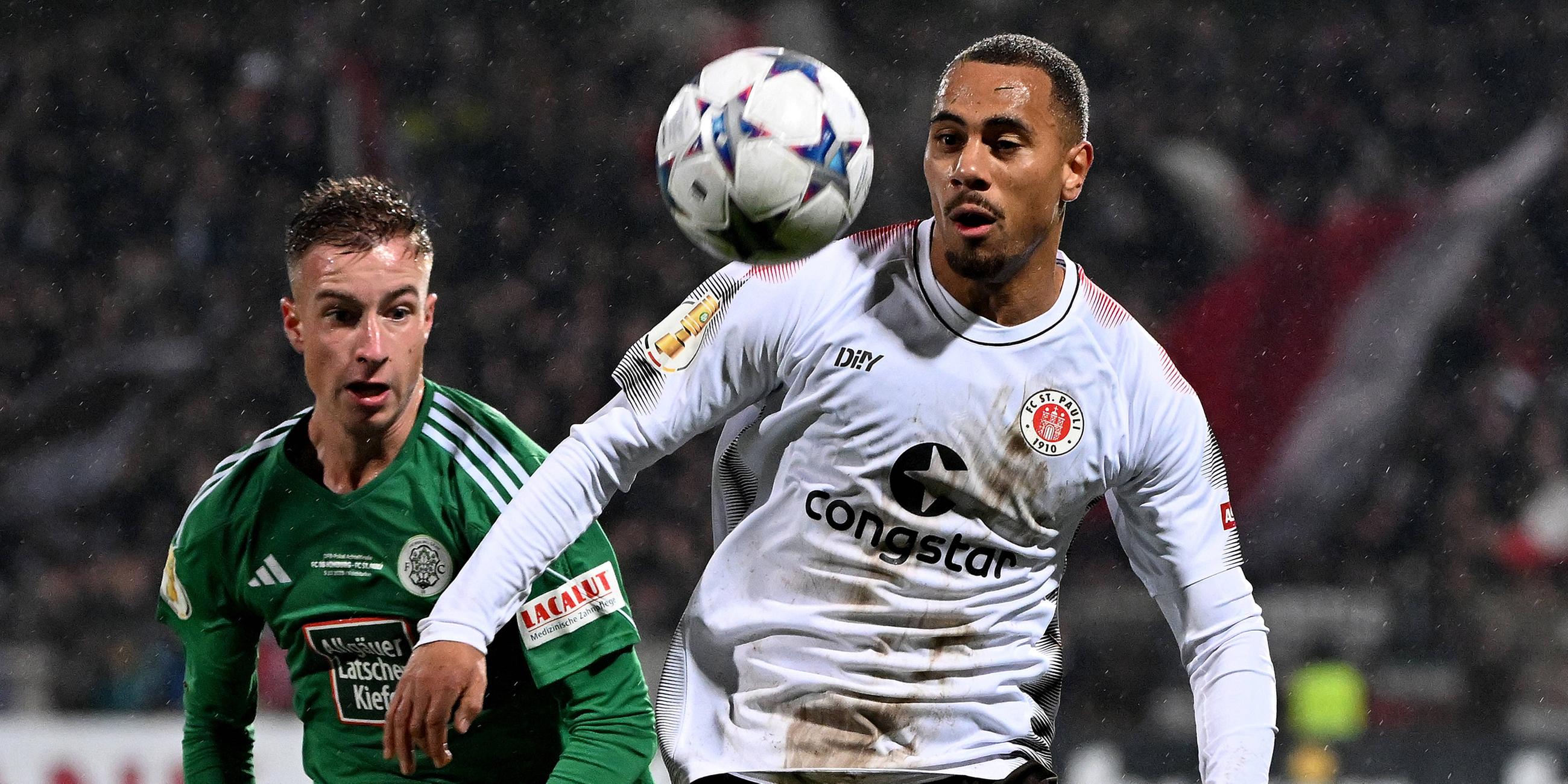 Tim Steinmetz (FC Homburg) und Etienne Amenyido (FC St.Pauli) im Zweikampf am 05.12.23.