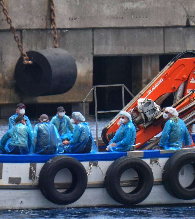 Personen in Schutzbekleidung und mit Masken werden mit einem Boot im Hafen von Granadilla auf Teneriffa von dem vom Hantavirus betroffene Kreuzfahrtschiff MV Hondius ausgeschifft