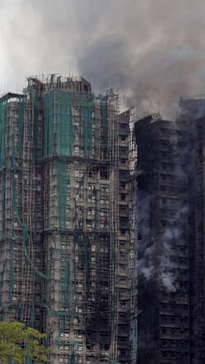 Rauch steigt aus einem Hochhaus in Tai Po, Hongkong, einen Tag nach einem verheerenden Brand, bei dem mindestens 44 Menschen starben.