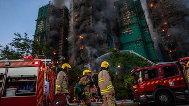 Einsatzkräfte der Feuerwehr versuchen das Feuer in einem Wohnkomplex in Hongkong unter Kontrolle zu bringen.