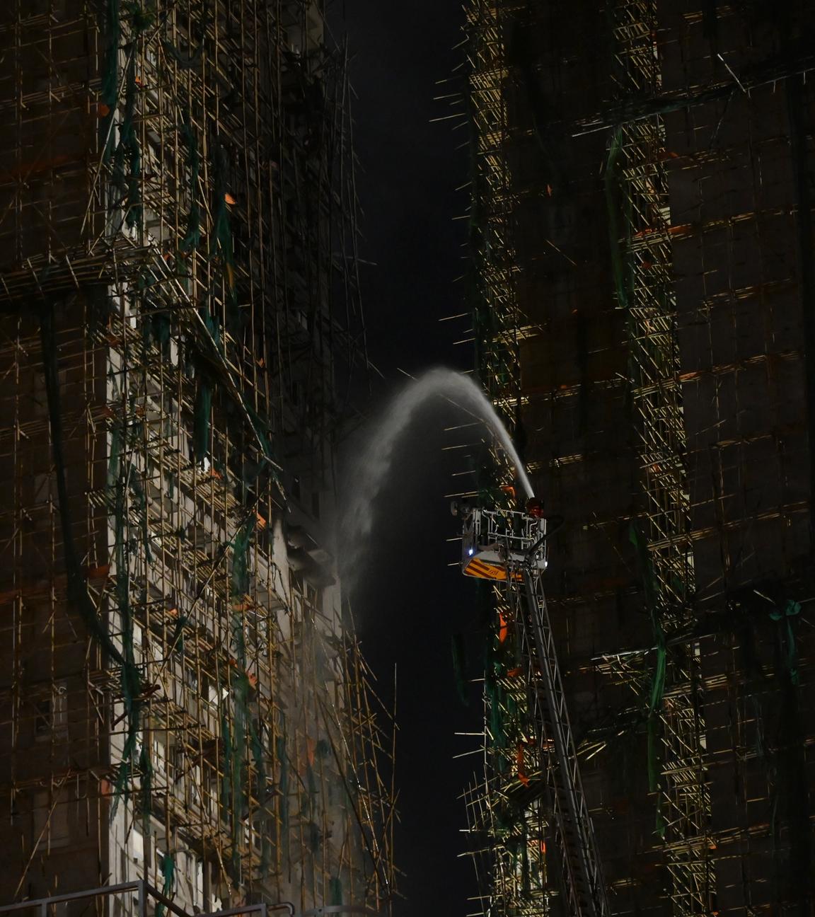 Die Feuerwehr spritzt Wasser auf Gebäude, die ein Großbrand am Wang Fuk Court erfasst hatte.