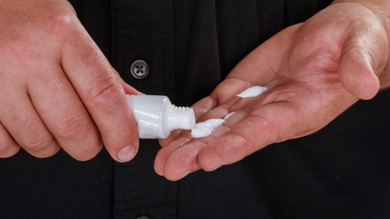 Ein Mann hat eine Creme in der Hand.