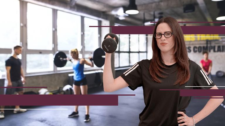 Salwa Houmsi mit angestengtem kritischen Gesicht hebt Hanteln hoch im Fitnessstudio.