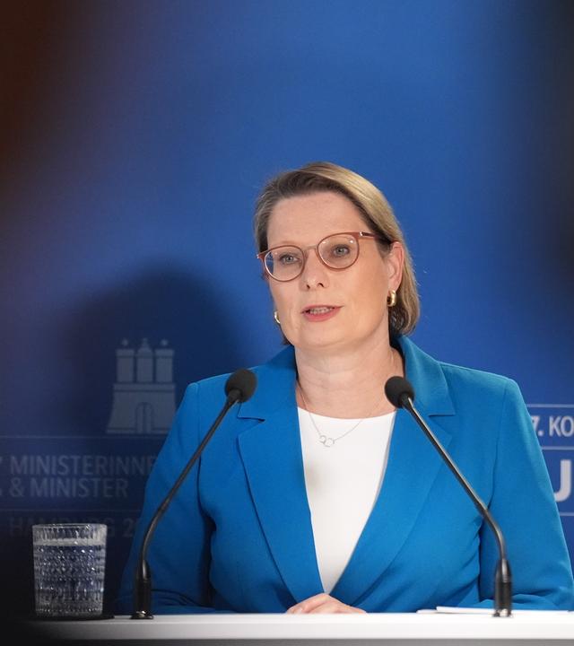 Justizministerin Hubig vor blauem Hintetgrund