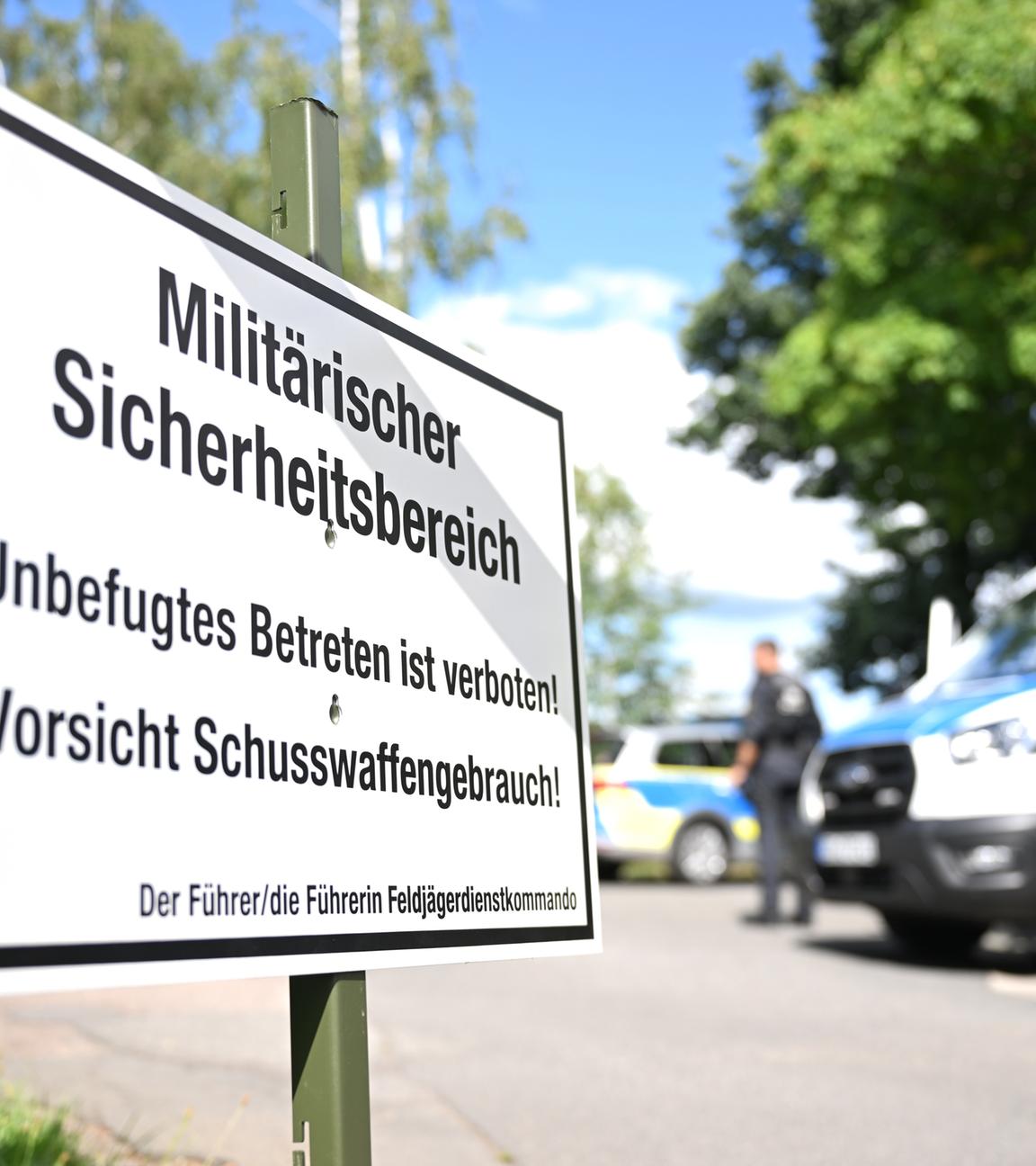  Polizisten sperren im Ortsteil Bahren eine Straße ab, während im Vordergrund ein Schild mit der Aufschrift Militärischer Sicherheitsbereich steht.