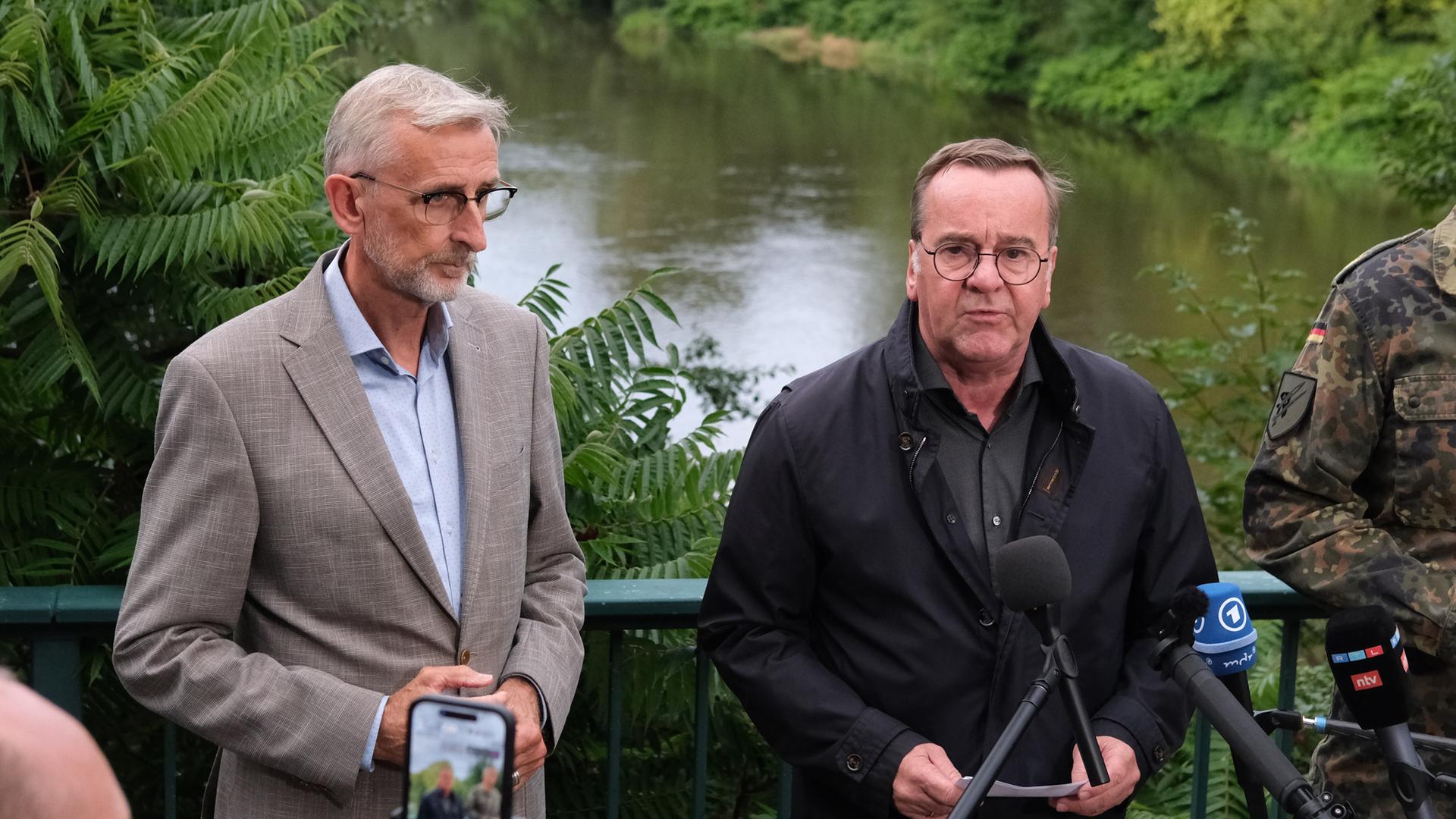 Sachsen, Grimma: Boris Pistorius (r, SPD) Bundesverteidigungsminister, und Armin Schuster (CDU), Sachsens Innenminister, geben in der Nähe des Unglücksortes eines Hubschrauberabsturzes ein Statement ab.