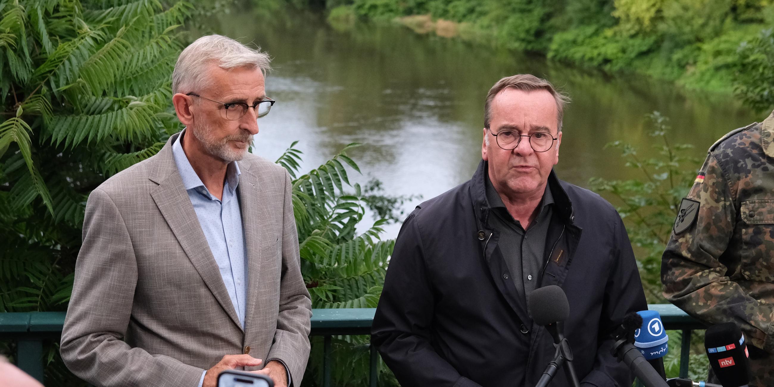 Sachsen, Grimma: Boris Pistorius (r, SPD) Bundesverteidigungsminister, und Armin Schuster (CDU), Sachsens Innenminister, geben in der Nähe des Unglücksortes eines Hubschrauberabsturzes ein Statement ab.