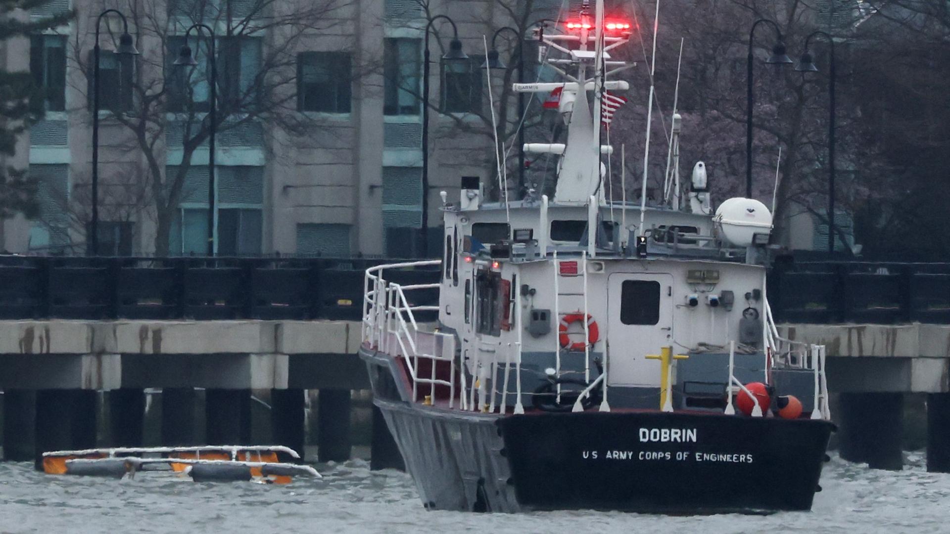 Ein Rettungsboot, daneben ragen aus der Wasseroberfläche Kufen eines Helikopters.