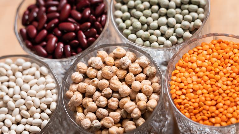 Verschiedene Hülsenfrüchte wie Linsen, Kichererbsen oder Kidneybohnen in Gläsern