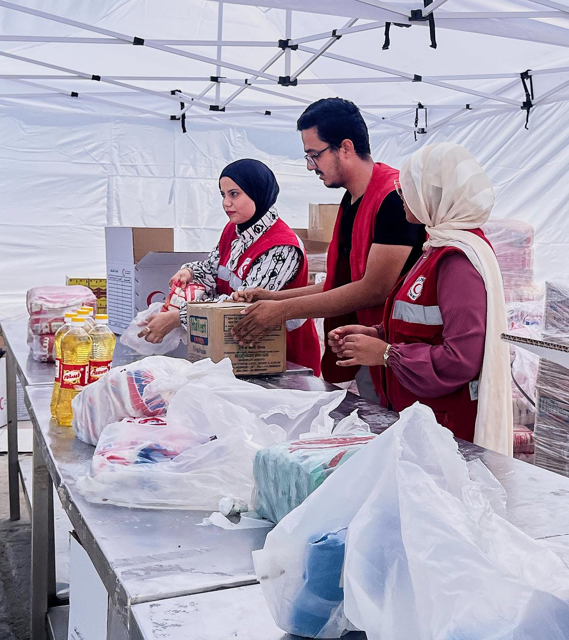 Mitglieder des ägyptischen Roten Kreuzes packen Pakete mit Lebensmitteln zur humanitären Hilfe für die Unterstützung der Menschen im Gazastreifen