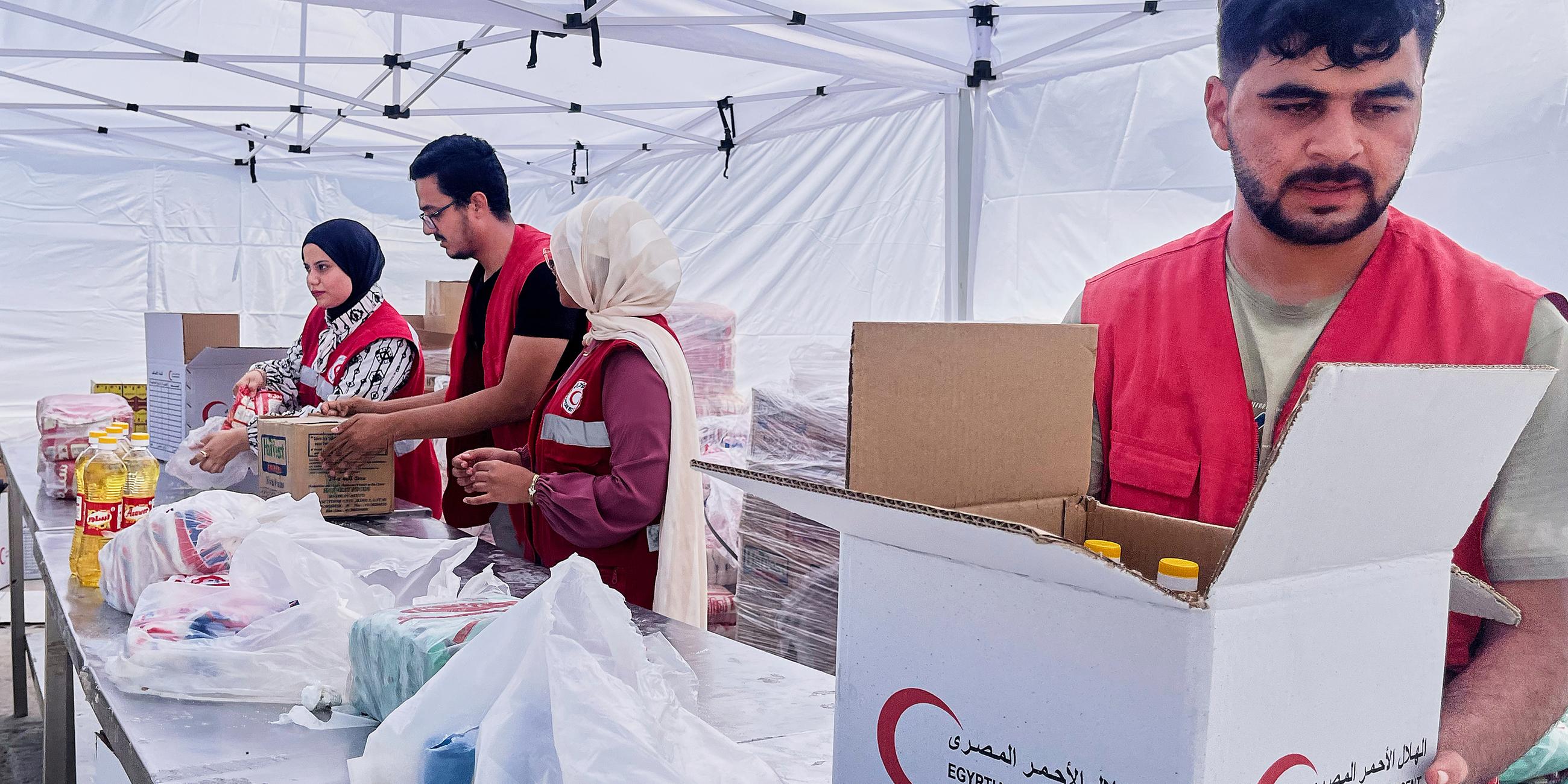 Mitglieder des ägyptischen Roten Kreuzes packen Pakete mit Lebensmitteln zur humanitären Hilfe für die Unterstützung der Menschen im Gazastreifen