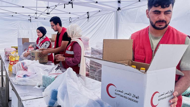 Mitglieder des ägyptischen Roten Kreuzes packen Pakete mit Lebensmitteln zur humanitären Hilfe für die Unterstützung der Menschen im Gazastreifen