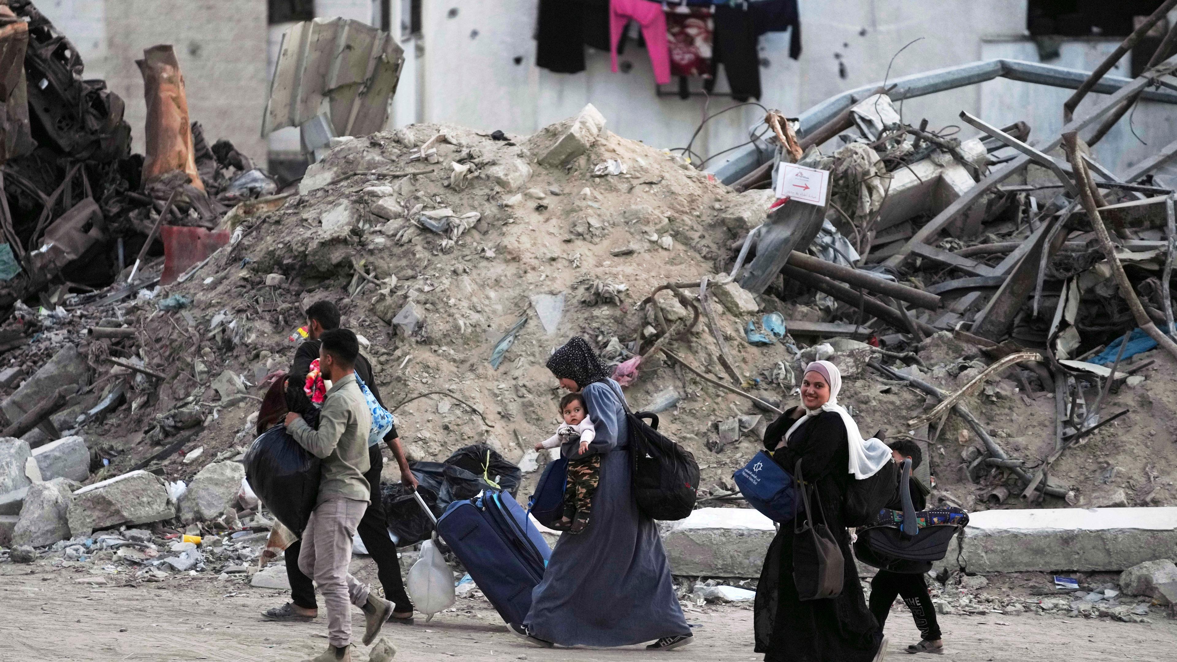 Palästinenser evakuieren, nachdem die israelische Armee eine Evakuierungswarnung für mehrere Schulen und ein Krankenhaus im Stadtteil Rimal in Gaza-Stadt ausgesprochen hat.