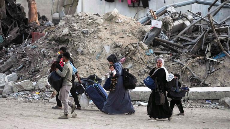 Palästinenser evakuieren, nachdem die israelische Armee eine Evakuierungswarnung für mehrere Schulen und ein Krankenhaus im Stadtteil Rimal in Gaza-Stadt ausgesprochen hat.