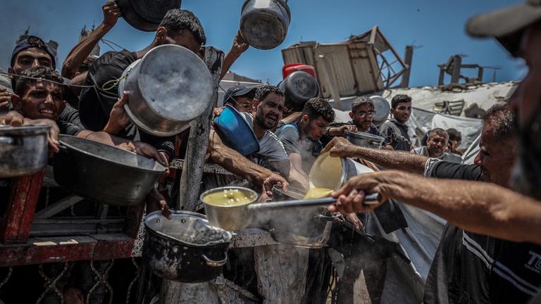 Crowds form as Palestinians, including children, line up in Gaza City, Gaza to receive food distributed by a charity amid ongoing Israeli blockade and attacks on Gaza on July 22