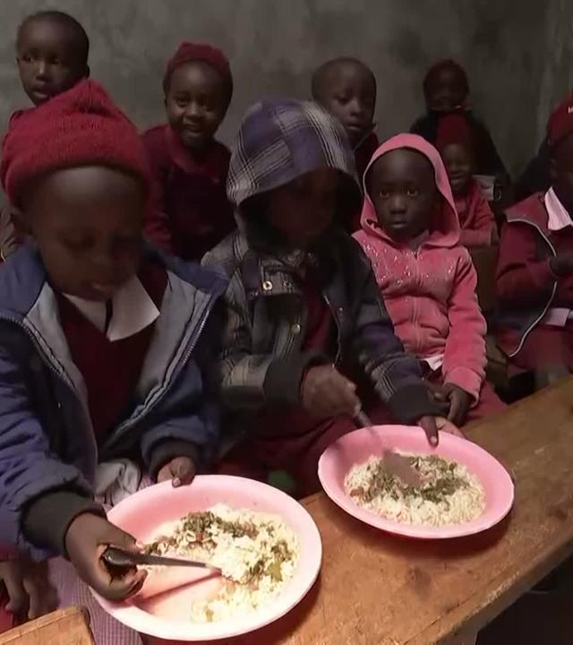 Kinder bekommen in einer Einrichtung Essen ausgegeben.