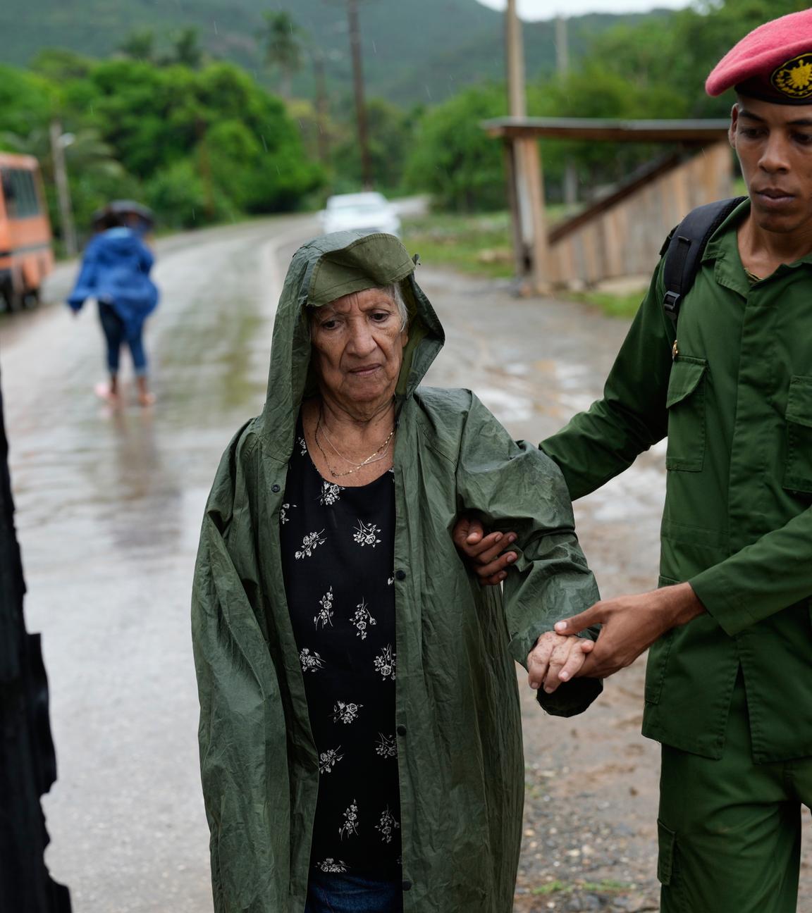 Ein Soldat hilft einer Frau bei der Evakuierung vor der Ankunft des Hurrikans Melissa. 
