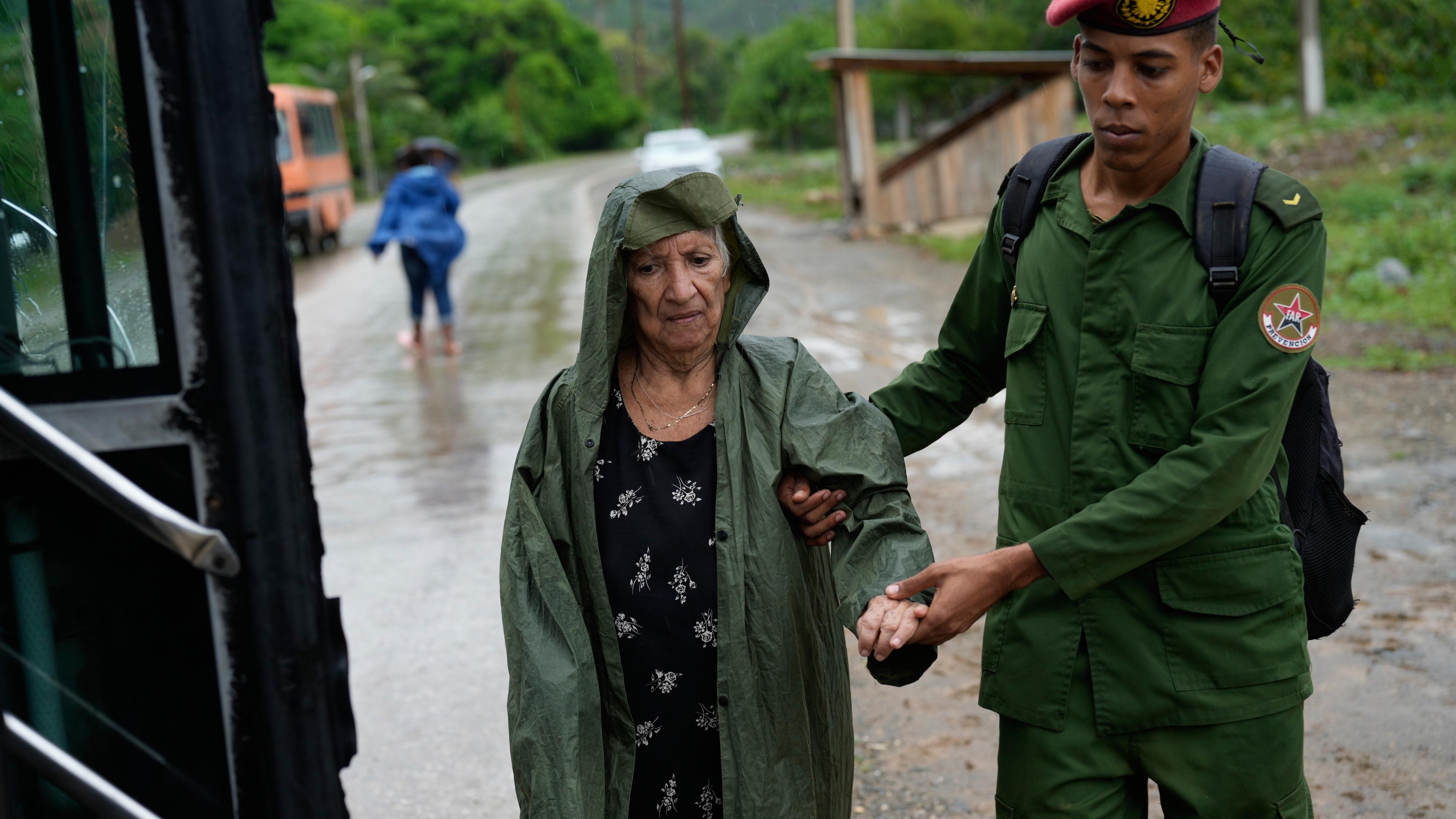 Ein Soldat hilft einer Frau bei der Evakuierung vor der Ankunft des Hurrikans Melissa. 