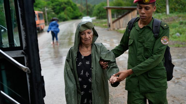 Ein Soldat hilft einer Frau bei der Evakuierung vor der Ankunft des Hurrikans Melissa. 