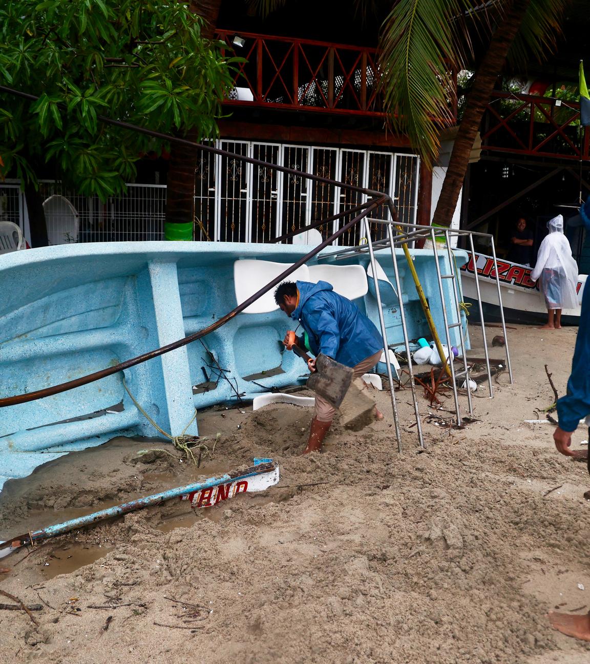 Ein Mann schaufelt Sand aus einem Boot, nachdem der Hurrikan «Erick» im südwestlichen Bundesstaat Oaxaca auf Land getroffen ist.