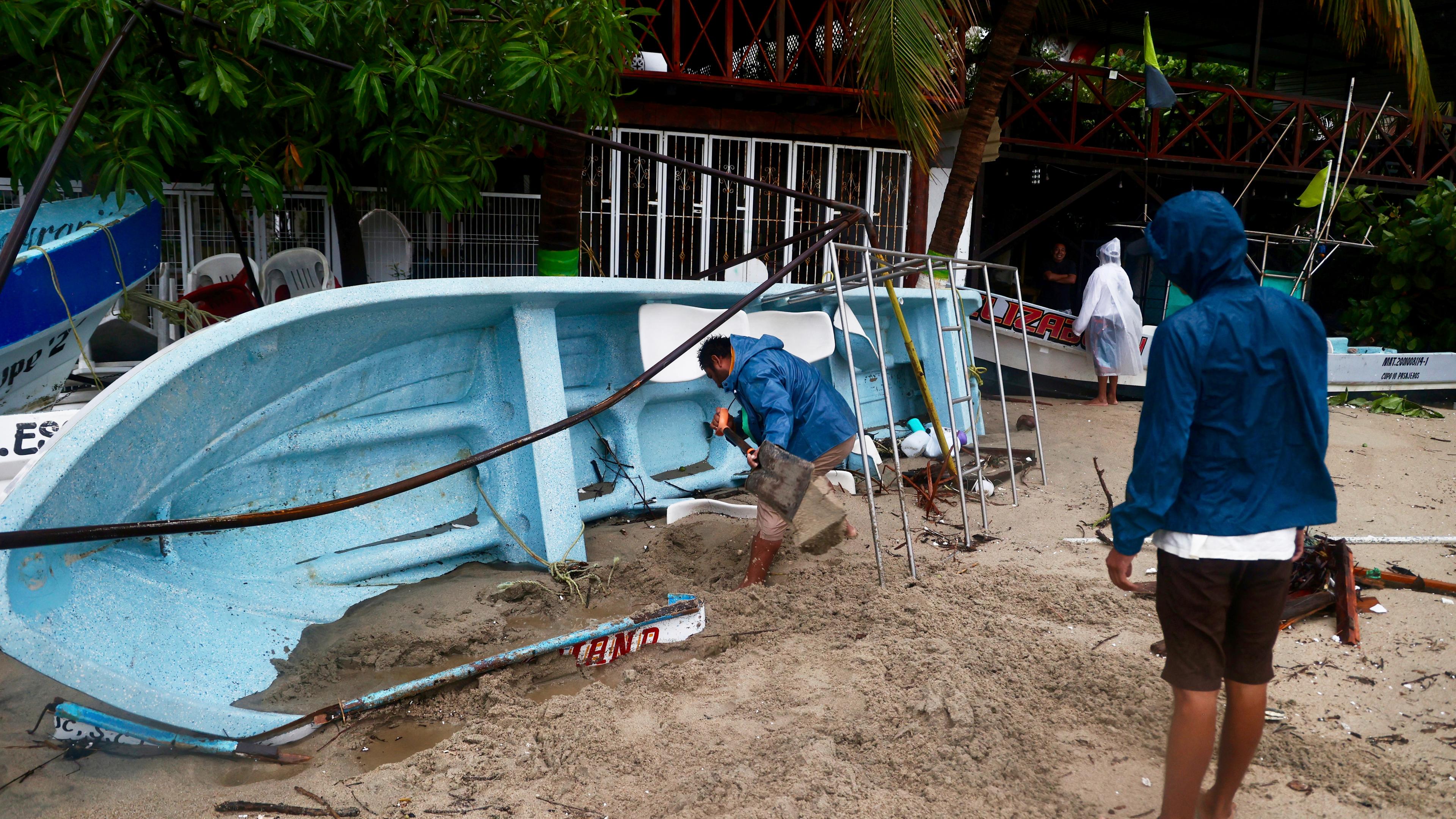 Ein Mann schaufelt Sand aus einem Boot, nachdem der Hurrikan «Erick» im südwestlichen Bundesstaat Oaxaca auf Land getroffen ist.